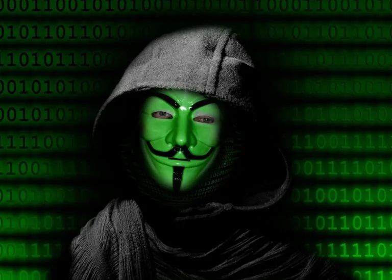 Zamaskowana postać w kapturze ze znakiem Anonymous na tle binarnego kodu
