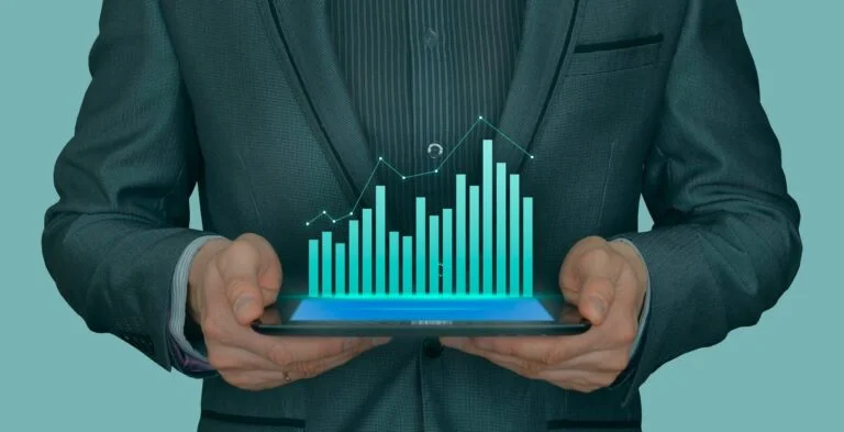 Biznesmen w garniturze trzymający tablet z hologramem wykresów wzrostu
