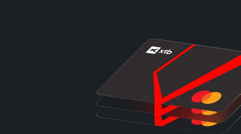 Trzy ciemnoszare karty Mastercard z logo XTB i czerwonym wzorem