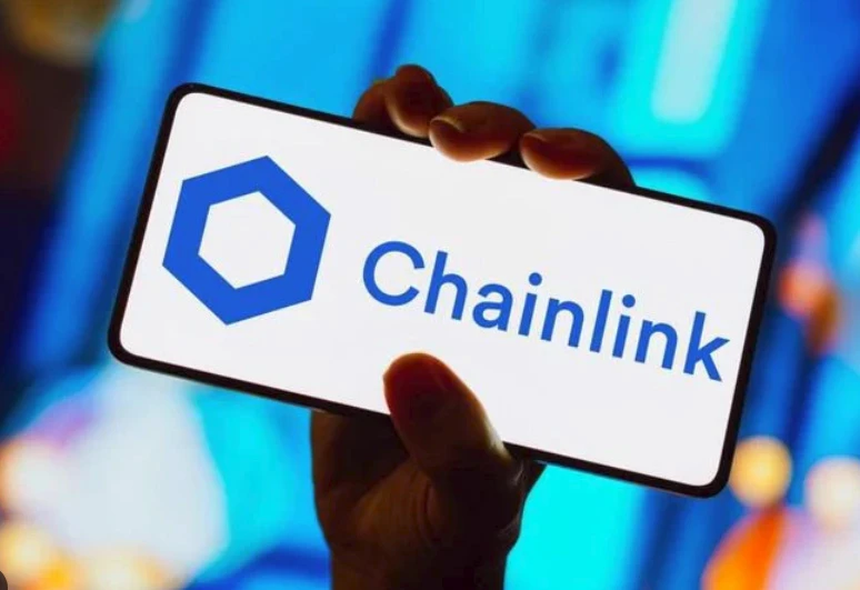 Dłoń trzymająca smartfon z logo i nazwą Chainlink